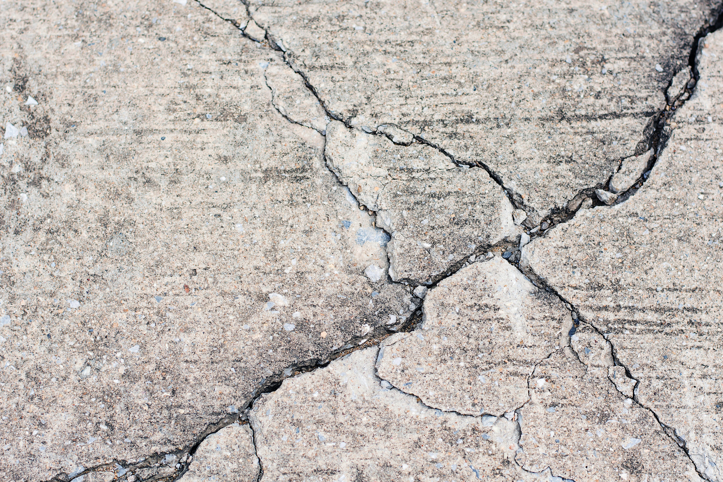 Cracked concrete surface in need of a garage floor coating.